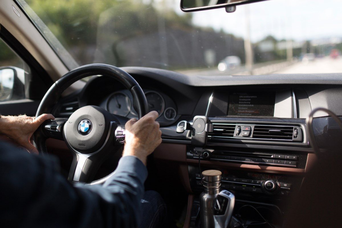 Een persoon achter het stuur van een BMW