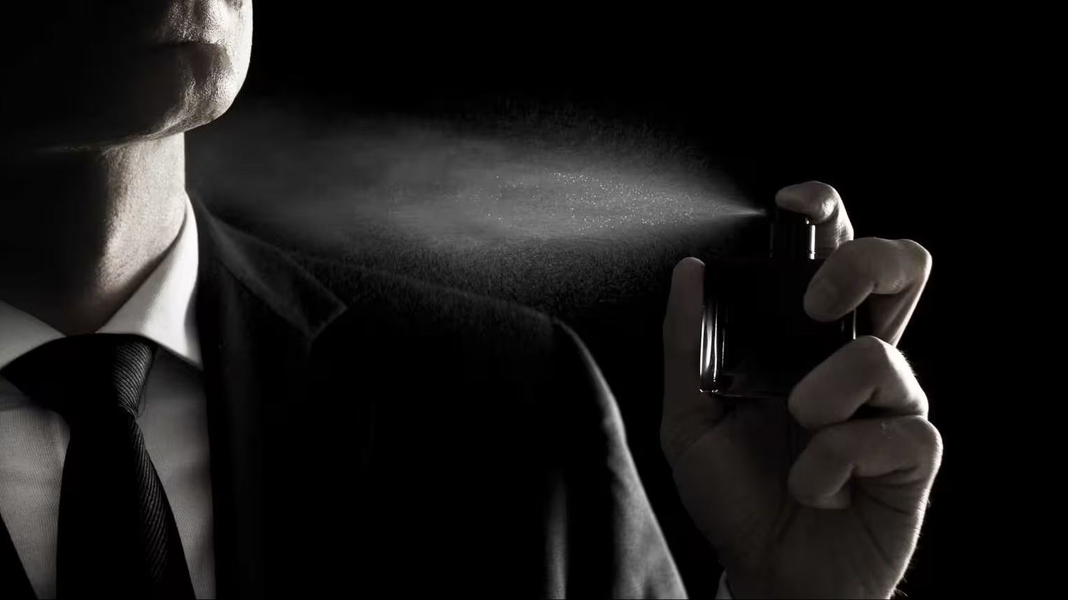 Een man die parfum op spuit