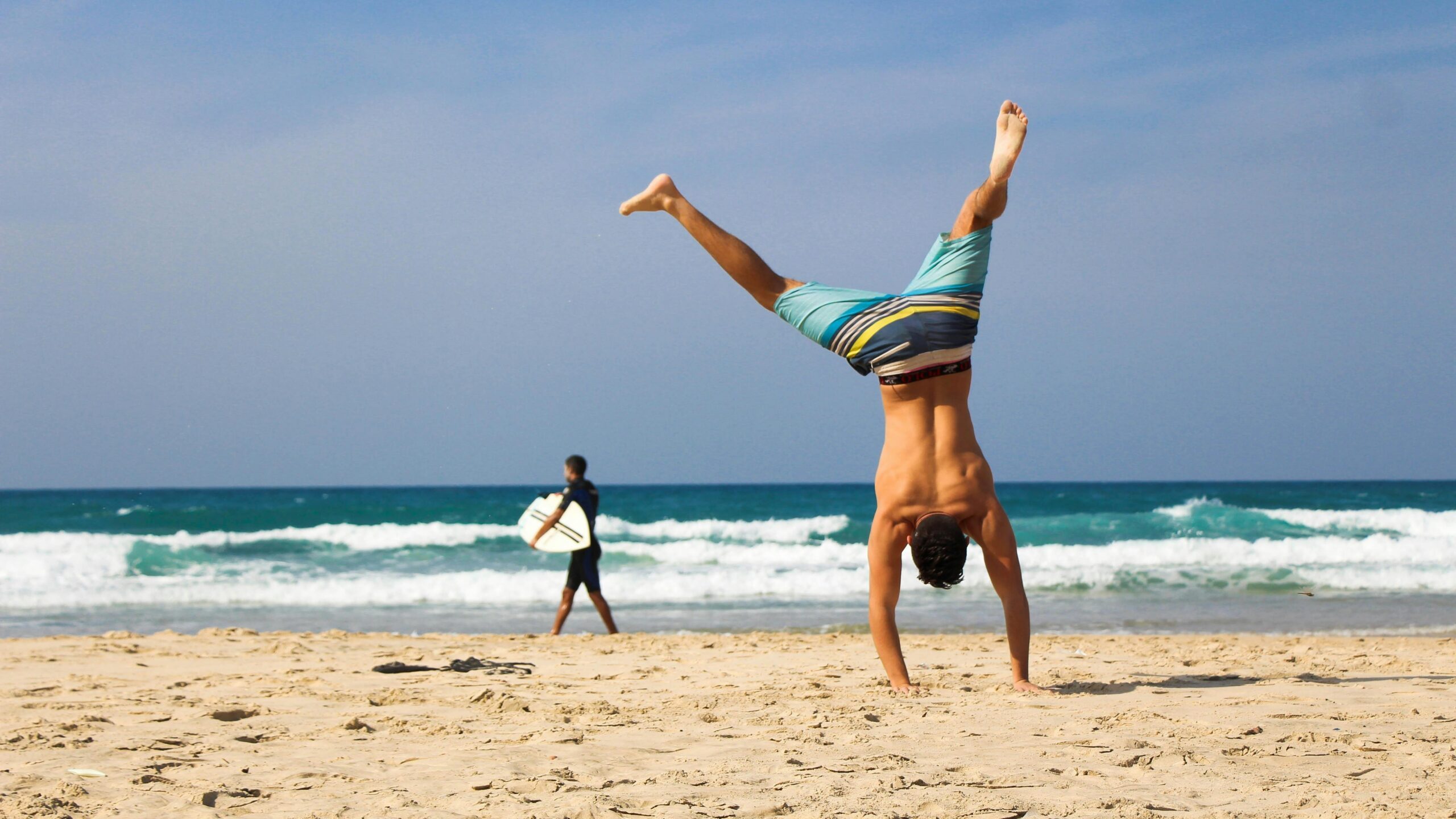Een fitte man die een handstand doet