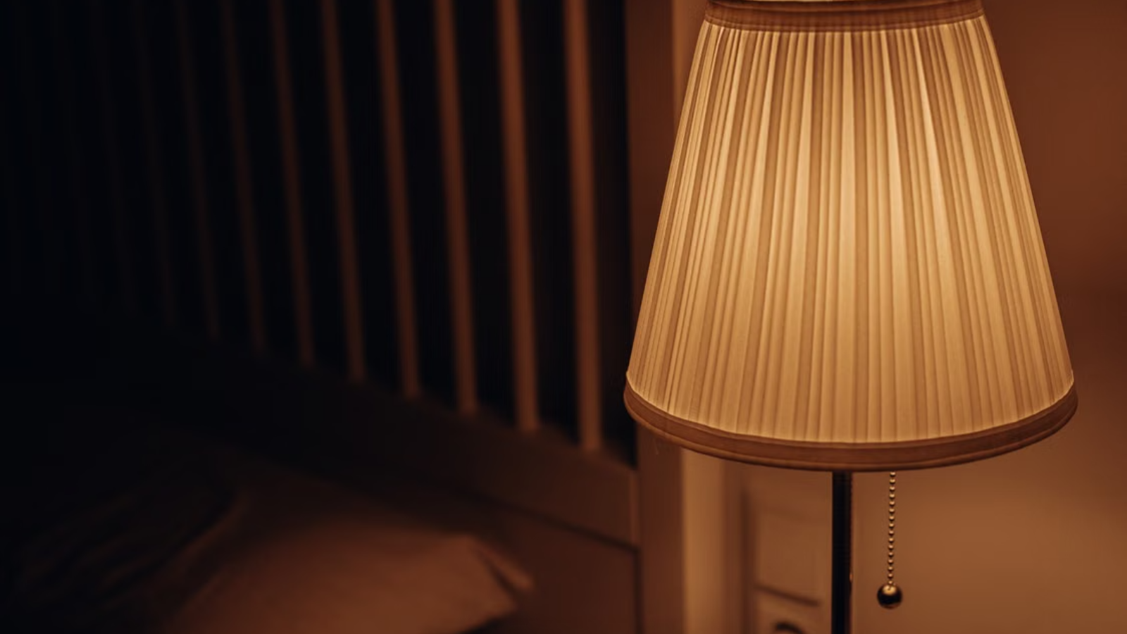 Een nachtlamp naast een bed