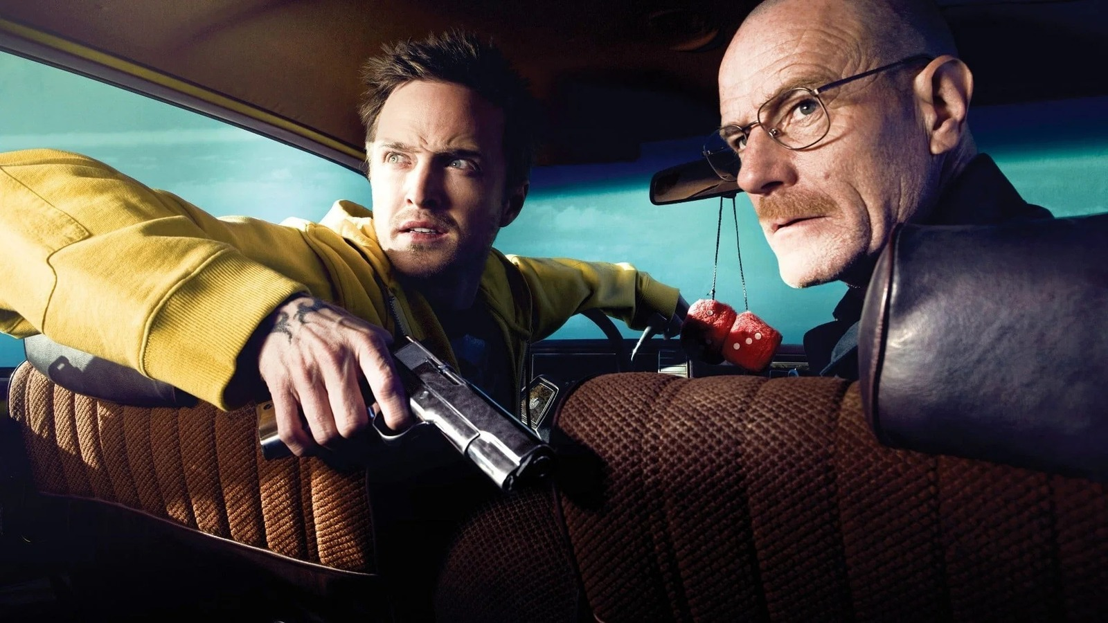 Jesse en Walter uit Breaking Bad kijken vanuit een auto naar achteren, Jesse heeft een pistool in zijn hand, Walter kijkt ernstig