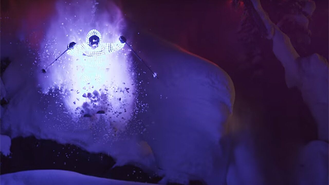 Illustratie voor: Deze 2 gasten skiën in het pikkedonker de berg af met LED suits aan, mooi effect!