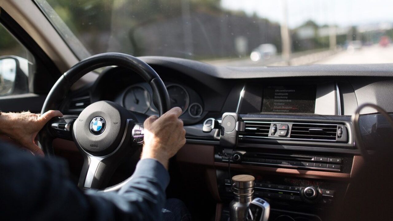 Een persoon achter het stuur van een BMW