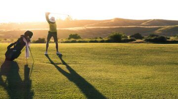 Een man aan het golfen op de golfbaan