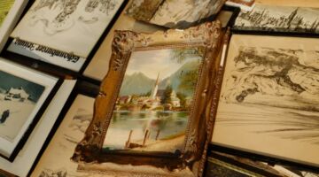 Oud ingelijst schilderij omringd door historische kunstwerken