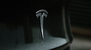 Het logo van Tesla op een zwarte auto
