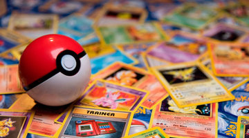 Een Pokéball ligt op een stapel met Pokémon kaarten