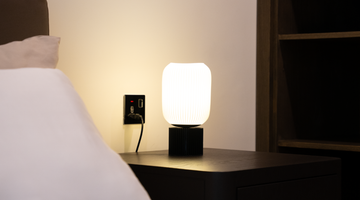 Een nachtlamp naast een bed