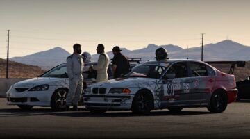Coureurs en auto's die klaarstaan om in actie te komen
