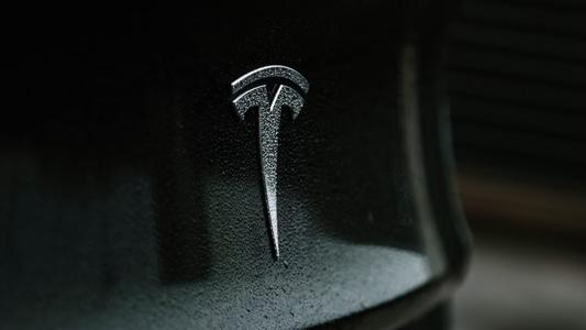 Het logo van Tesla op een zwarte auto