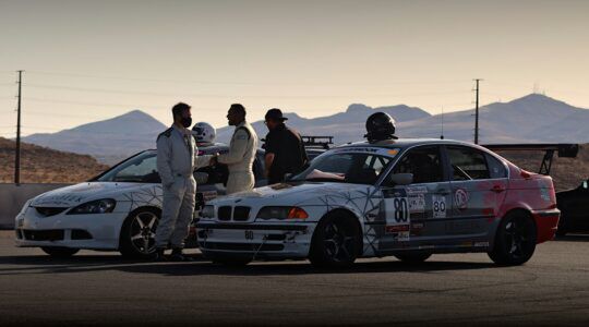 Coureurs en auto's die klaarstaan om in actie te komen
