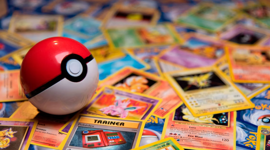 Een Pok&eacute;ball ligt op een stapel met Pok&eacute;mon kaarten