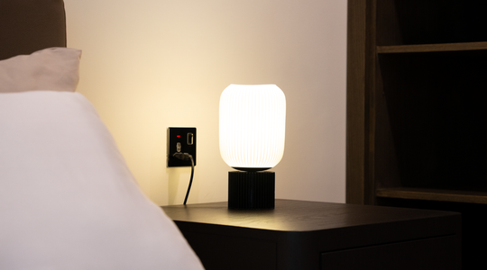 Een nachtlamp naast een bed